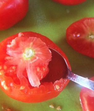 Hollowing out tomatoes for stuffing.