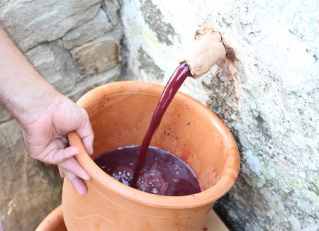 Nikos gathers the must in clay pots.