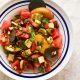 Greek salad with peaches, watermelon, tomatoes, capers and pistachios