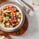 Greek salad with chickpeas, tomatoes and feta cheese. Top view. Grey background.