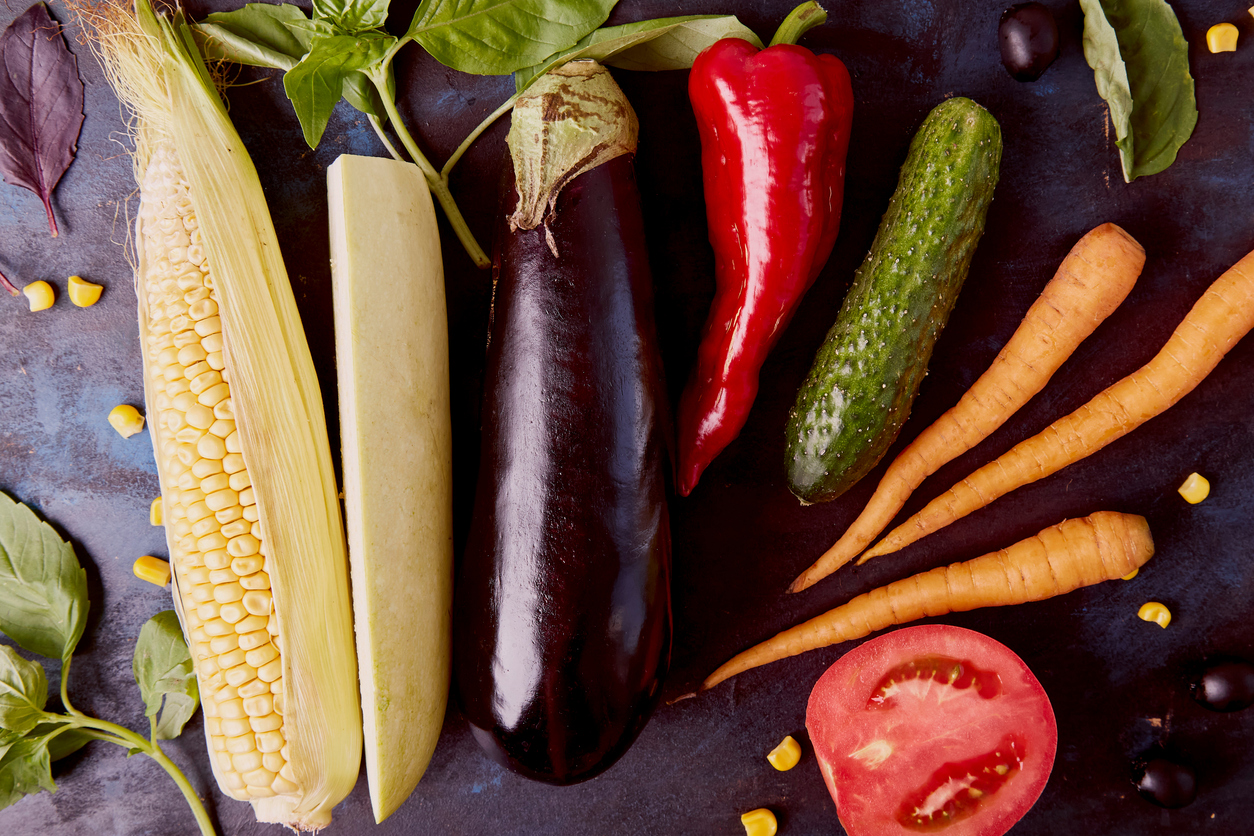 A vibrant display of greens, herbs, and vegetables at an Ikarian market, showcasing the plant-based longevity diet of the Ikarians, who are known for their long-lived and healthy lifestyle.